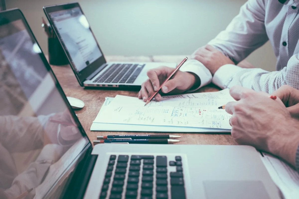 Laptop, charts, and notes on a desk — scoping work and discovery deliverables